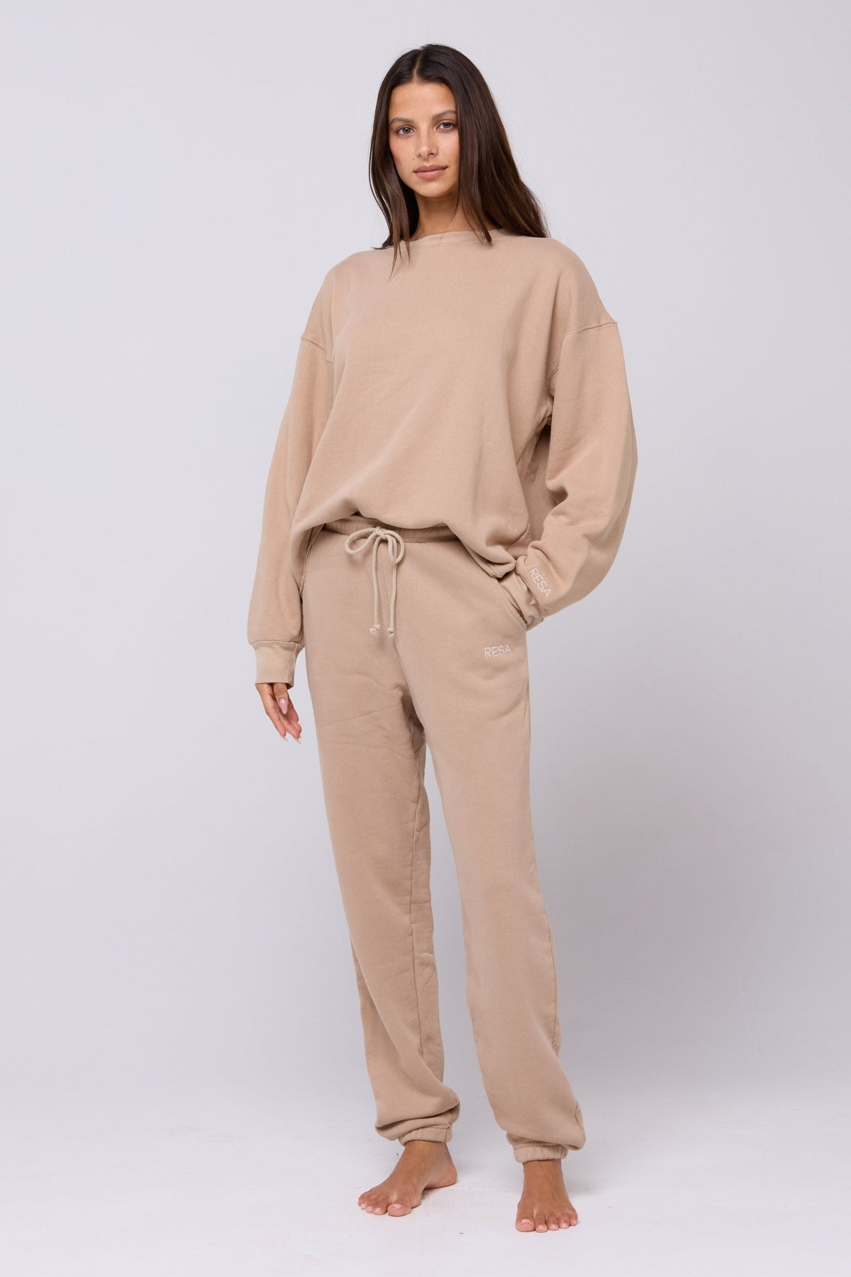 This is an image of Bodhi Sweatpants in Sand - RESA featuring a model wearing the dress