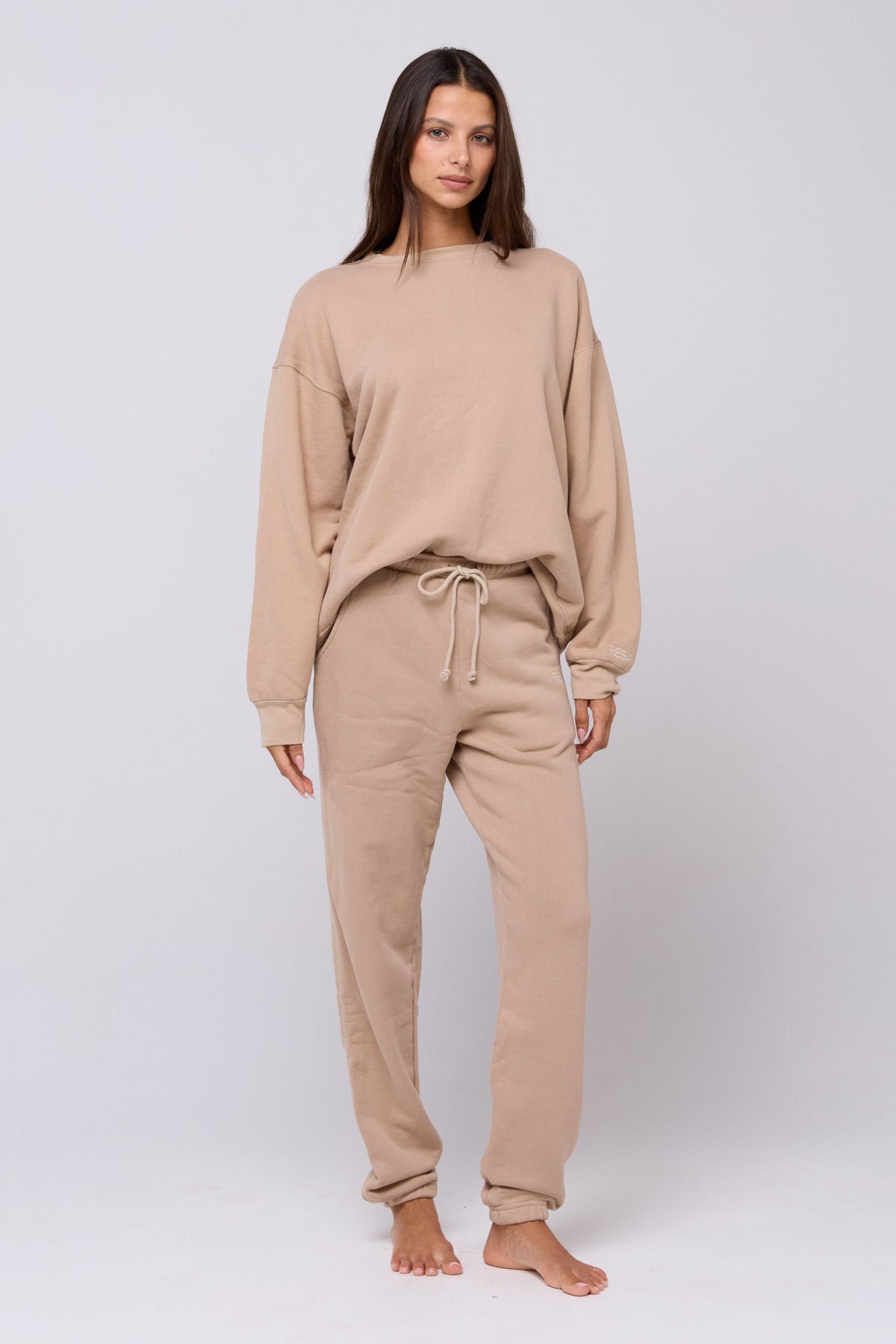 This is an image of Bodhi Sweatpants in Sand - RESA featuring a model wearing the dress
