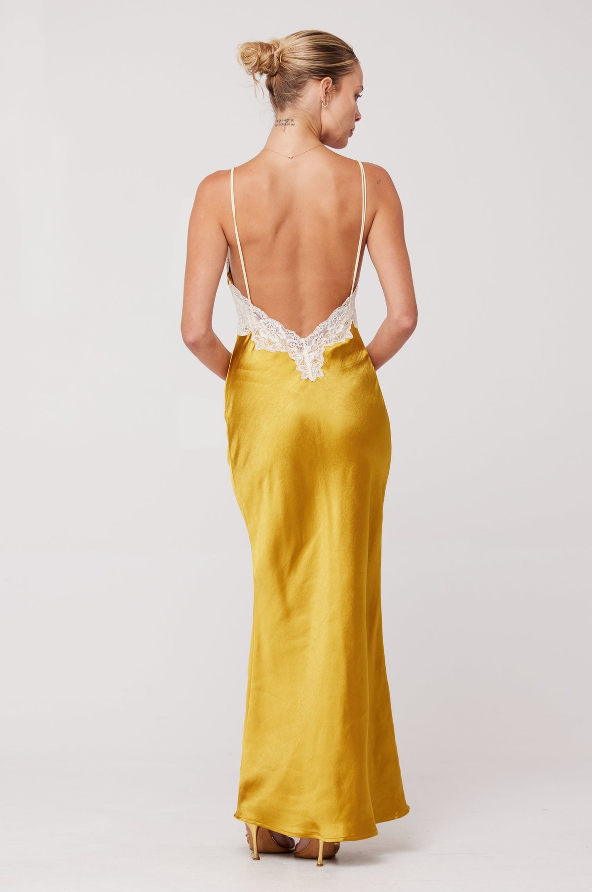 This is an image of Celine Dress in Gold - RESA featuring a model wearing the dress