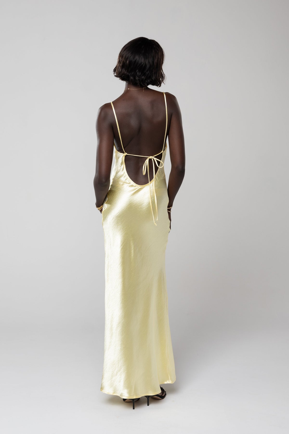 This is an image of River Slip in Butter - RESA featuring a model wearing the dress