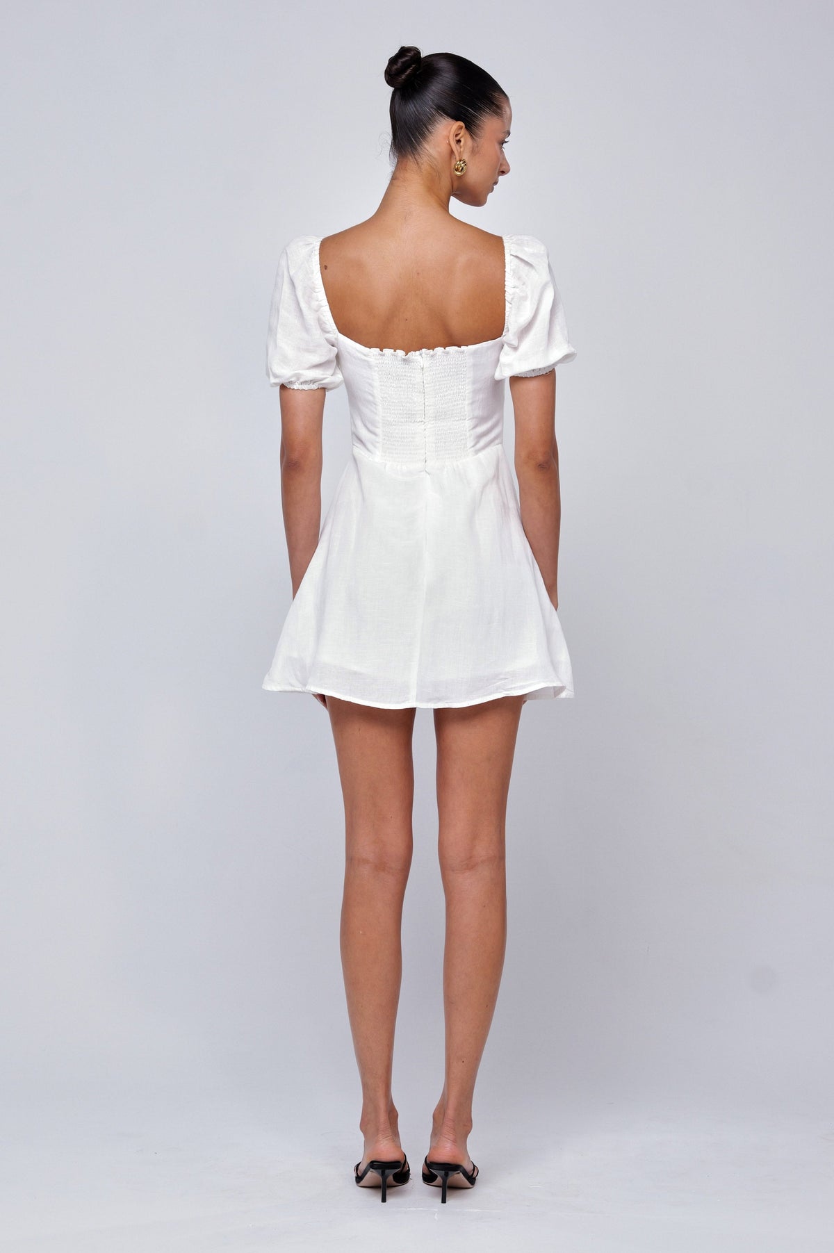 This is an image of Winnie Mini in White Linen - RESA featuring a model wearing the dress