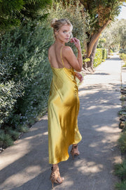 This is an image of Berri Slip in Gold - RESA featuring a model wearing the dress