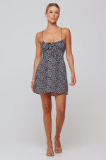 This is an image of Juniper Mini in Black Polka Dot - RESA featuring a model wearing the dress