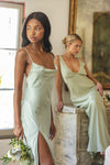 This is an image of River Slip in Sage - RESA featuring a model wearing the dress