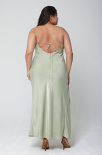 This is an image of River Slip in Sage - RESA featuring a model wearing the dress