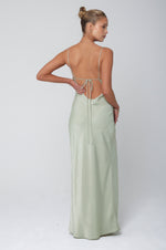 This is an image of River Slip in Sage - RESA featuring a model wearing the dress