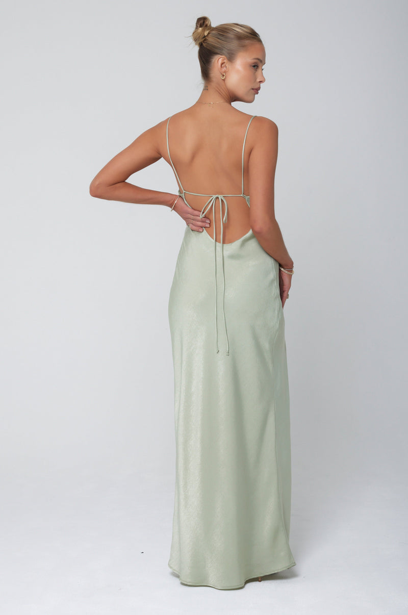 This is an image of River Slip in Sage - RESA featuring a model wearing the dress