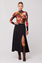 This is an image of Skatie Midi Skirt in Black - RESA featuring a model wearing the dress